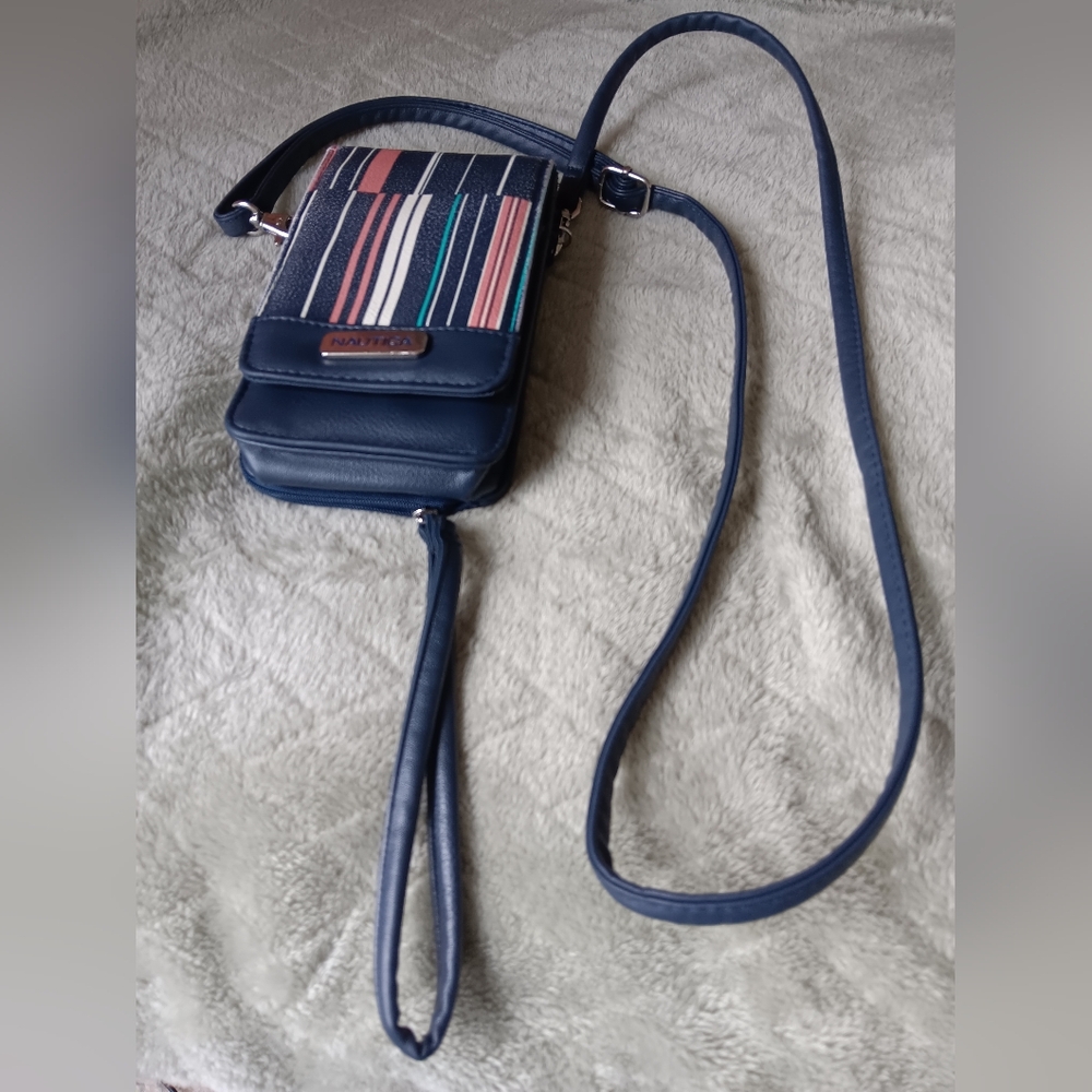 A crossbody bag holds a cell phone.